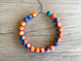 Betty chunky bead necklace with glossy orange, teal and purple acrylic beads and a silver-tone clasp on wood