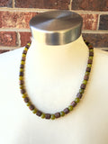 DLD Jewelry mens beaded gemstone necklace with one strand of alternating olive green jade and brown wood drum shaped beads laying on a white mannequin.
