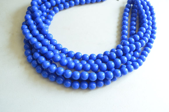 A beaded multi strand statement necklace made with cobalt blue acrylic beads.