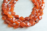 A beaded multi strand statement necklace made with brown amber acrylic beads
