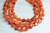 A beaded multi strand statement necklace made with brown amber acrylic beads