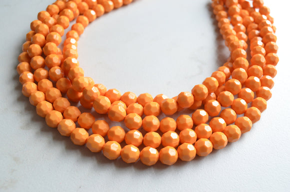 A beaded multi strand statement necklace made with yellow orange lucite beads. 